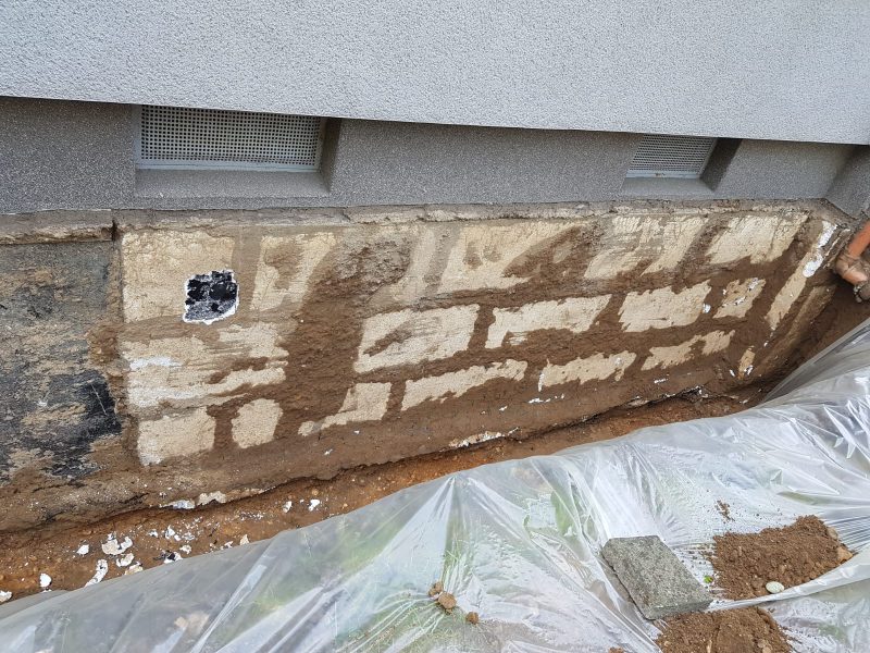 Freigelegtes Bruchsteinfundament mit abgetragener Altabdichtung vor der Kelleraußenabdichtung
