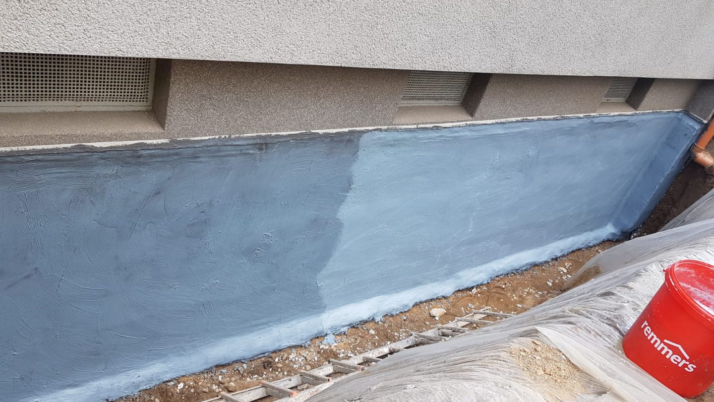 Frisch aufgetragene mineralische Dichtungsschlämme auf einer freigelegten Kelleraußenwand in Krefeld