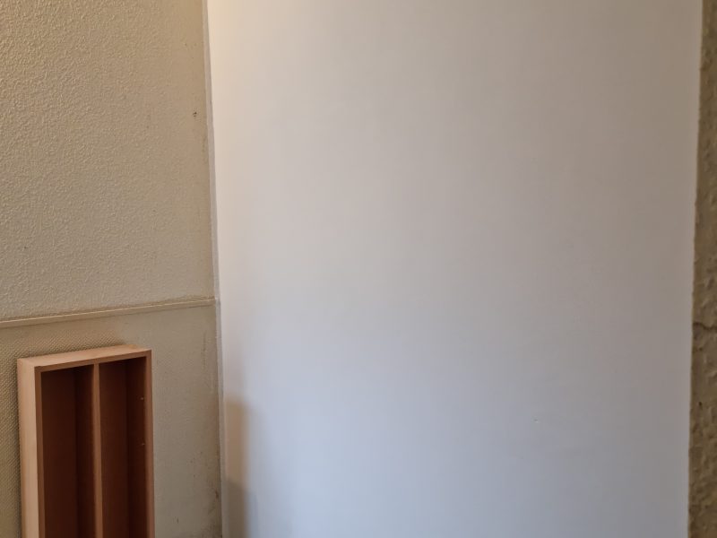 Glatt verputzte helle Wandfläche in einem Hausflur nach abgeschlossener Putzsanierung
