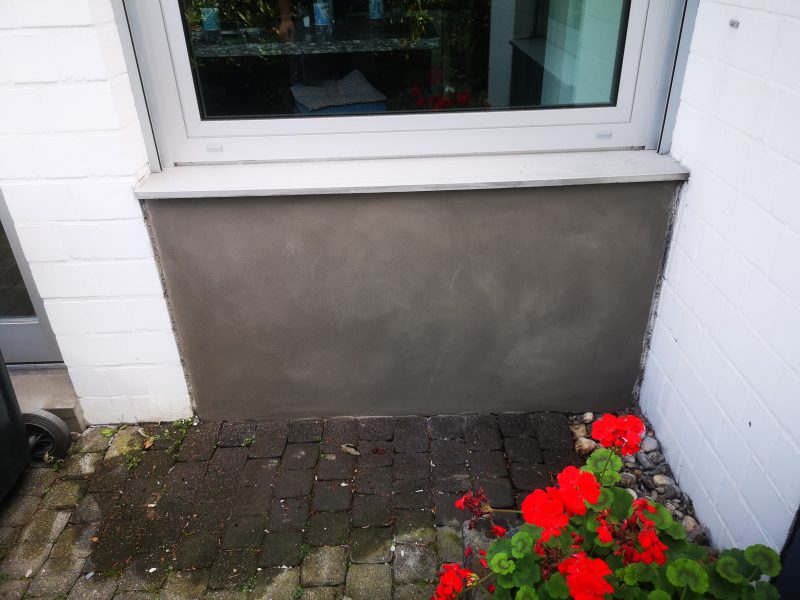 Sanierte Betonfläche unterhalb eines Fensters an der Hausfassade